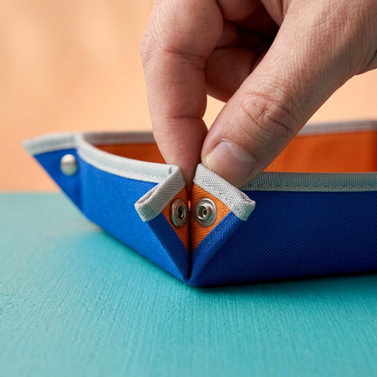 AI concept hand demonstrating the proposed tray corner snap arrangement.